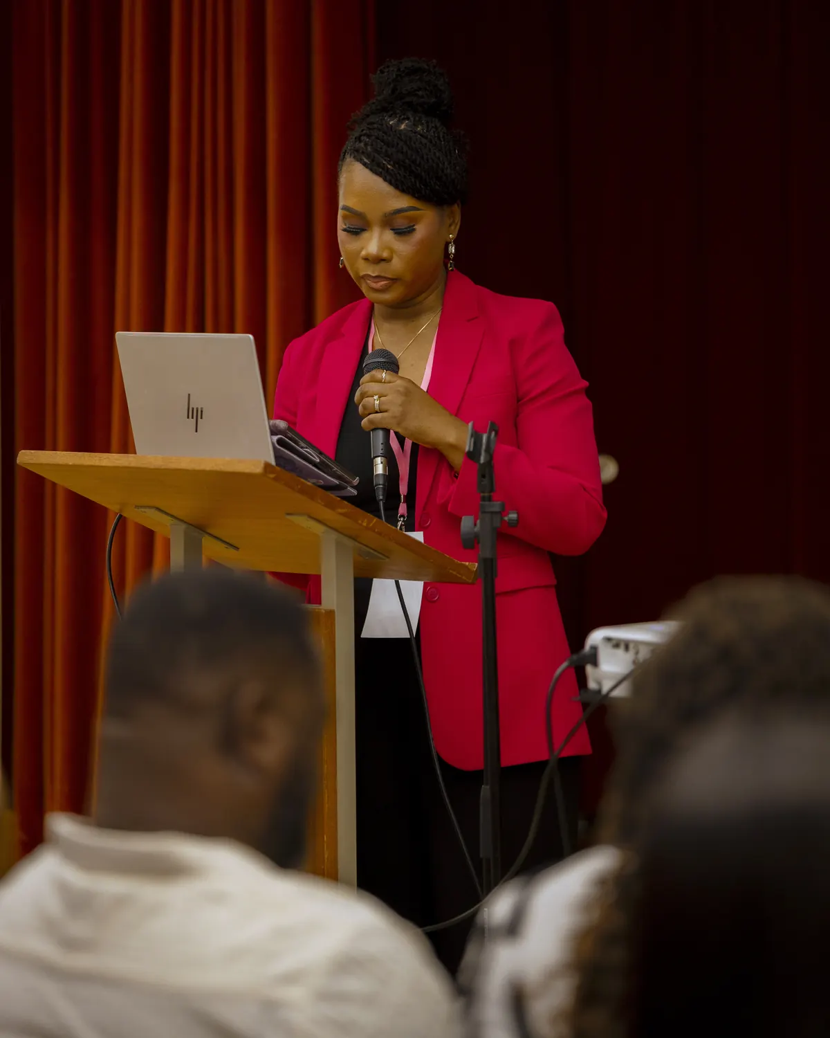 A speaker at the podium holding a microphone during the summit